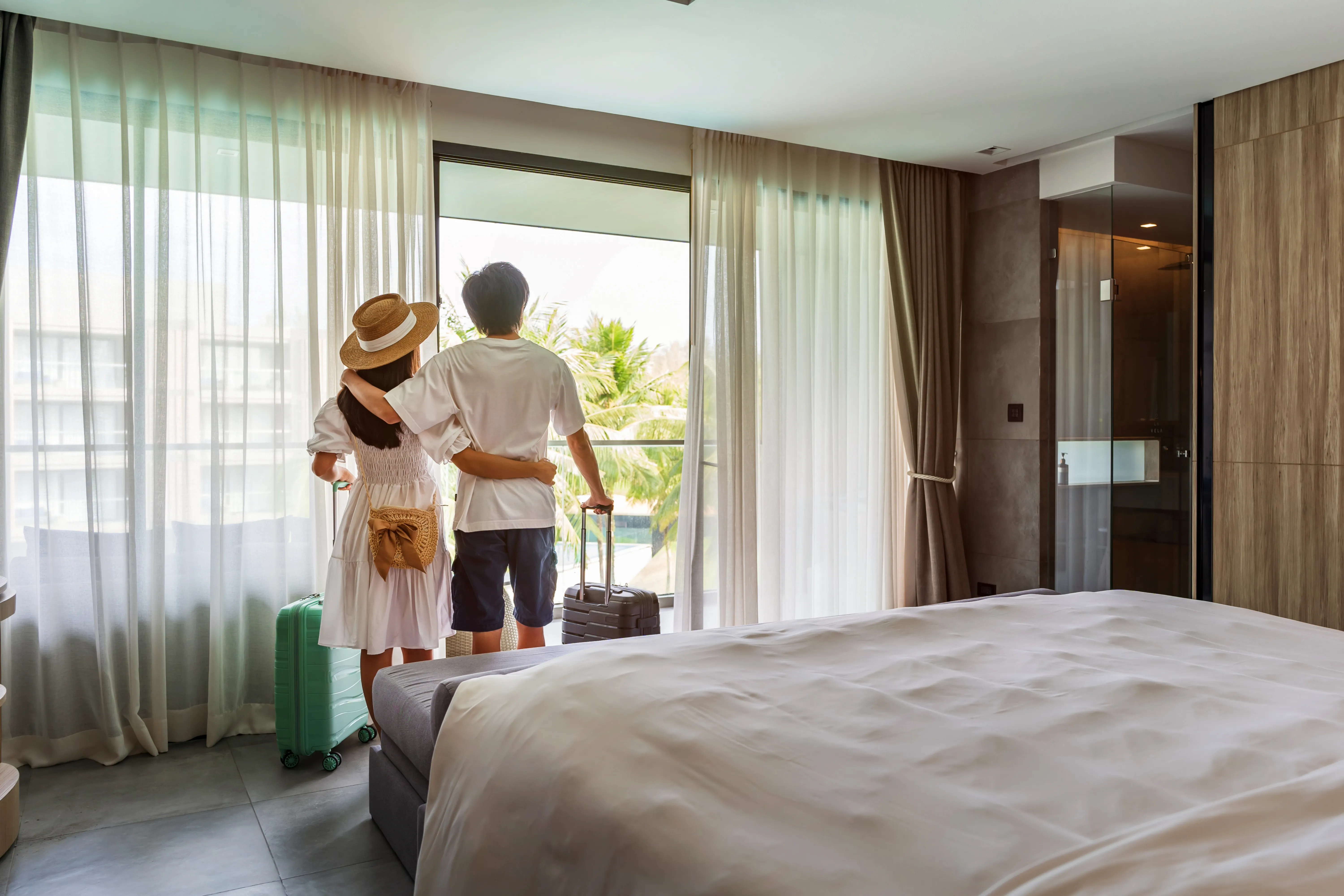 Couple arriving at hotel room with suitcases